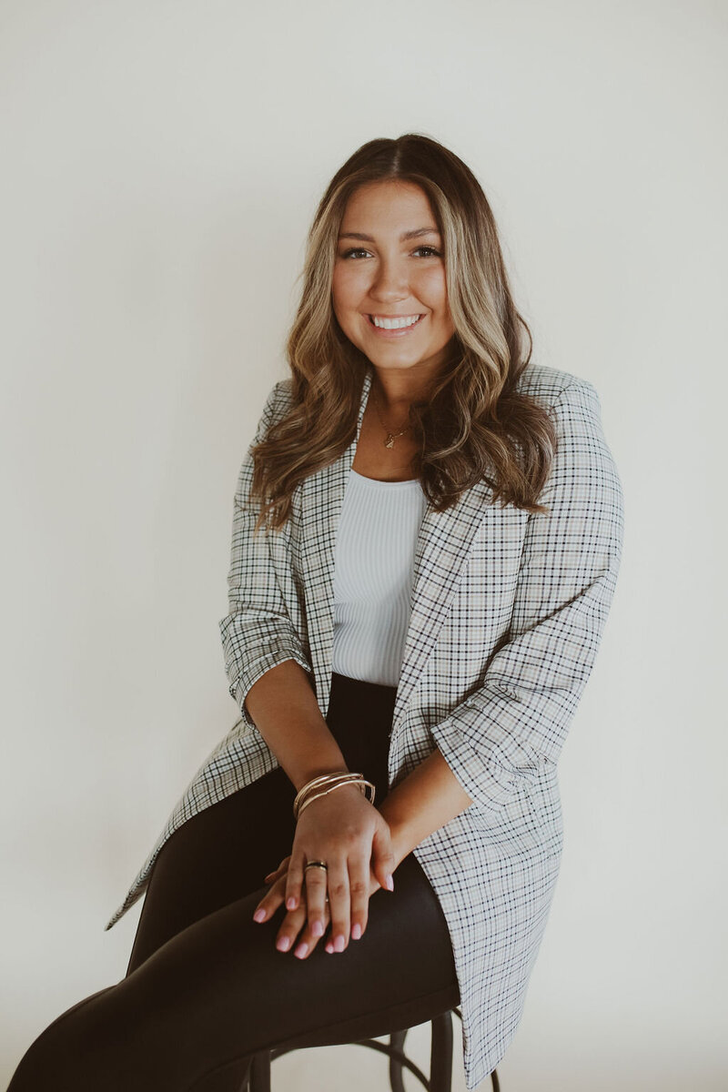 woman smiling while sitting on a stool