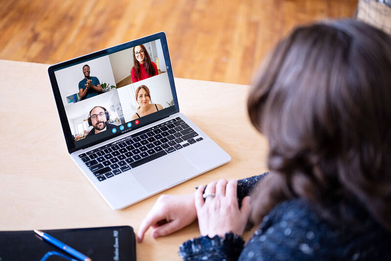 Chris participating in a virtual group call on her laptop with four people on screen.