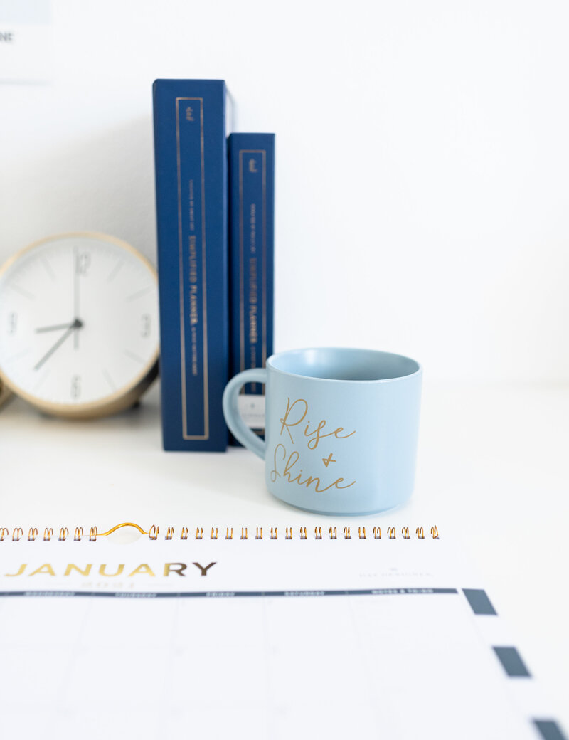desk with books, clock, and coffee mug