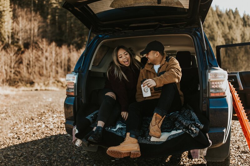 couple sitting in car trunk