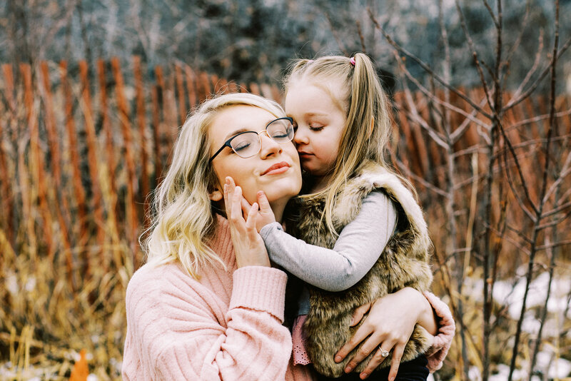 toddler snuggles with mom at a boulder colorado outdoor photosession