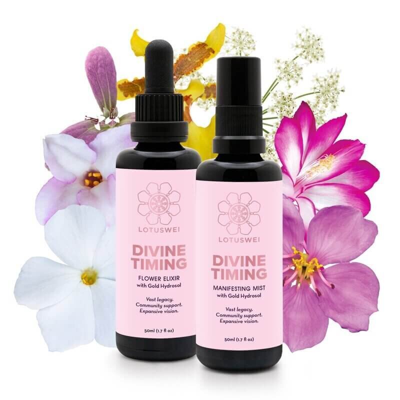 Two bottles of Lotuswei Divine Timing elixirs and mist are displayed in front of vibrant, colorful flowers