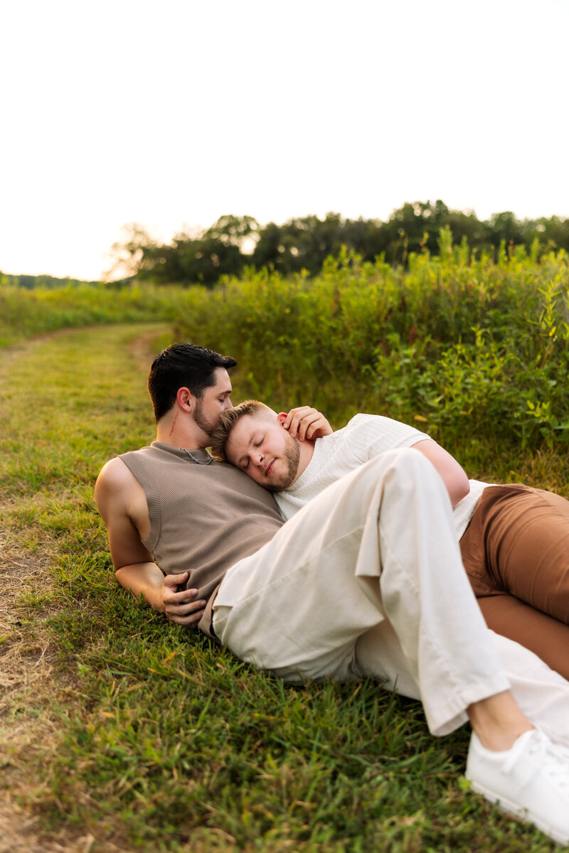Couple standing in an embrace while smiling at each other.