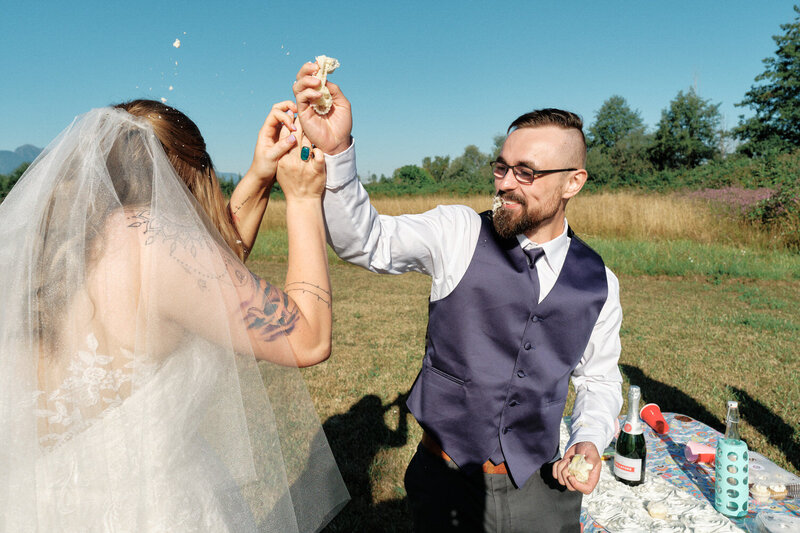 Cake flies through the air as the groom tries to smash cake on the bride