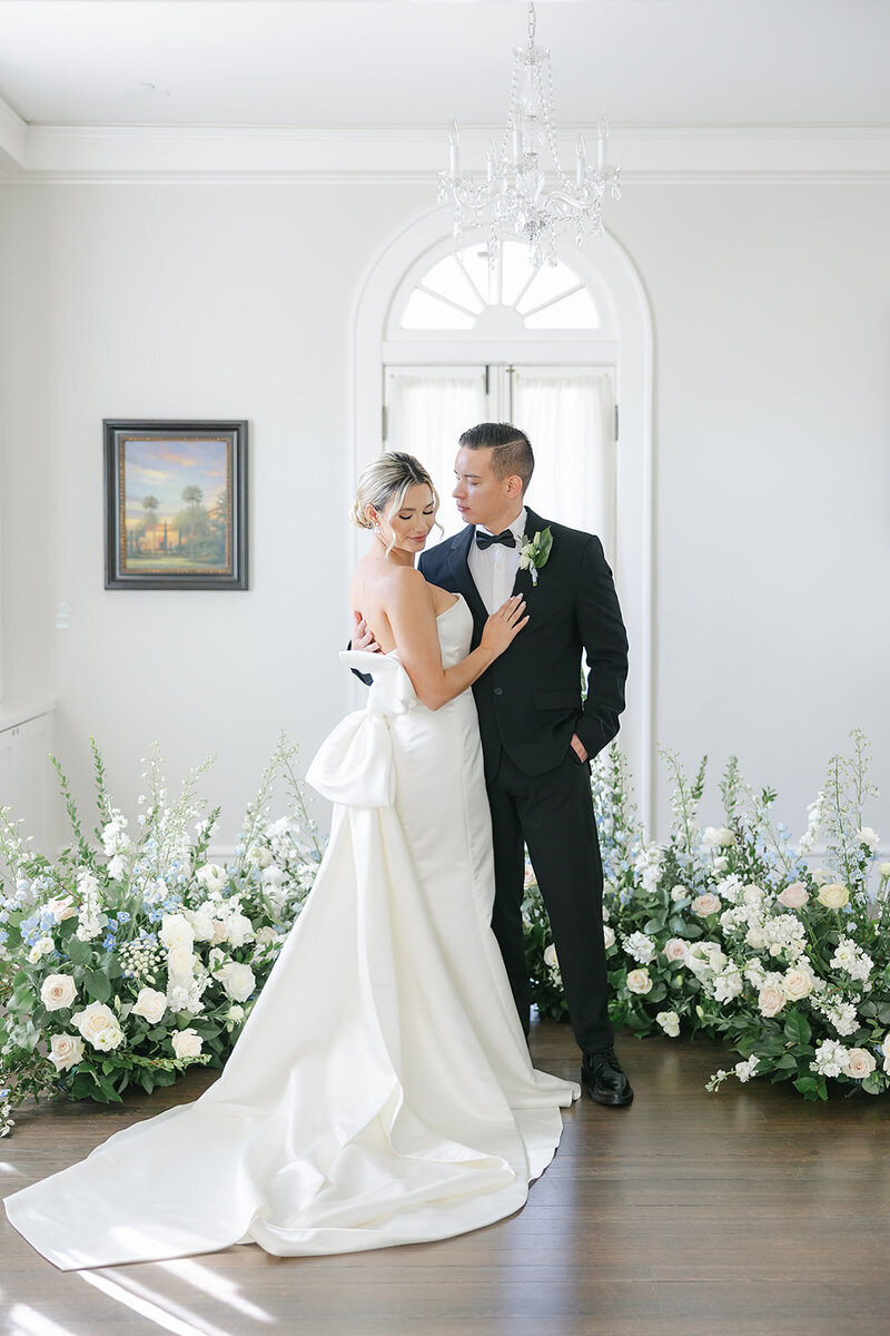 Couple in wedding attire at Capen House in Winter park surrounded by flowers