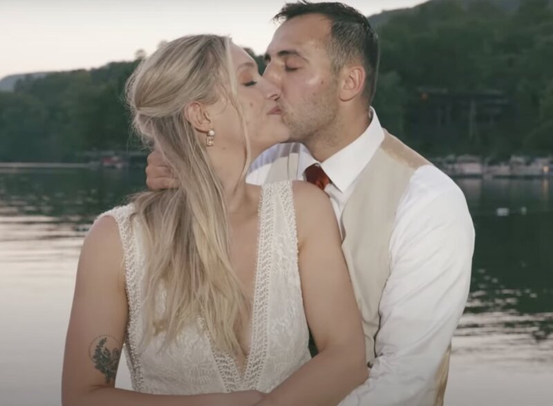 A person kissing their partner on the cheek on their wedding day 