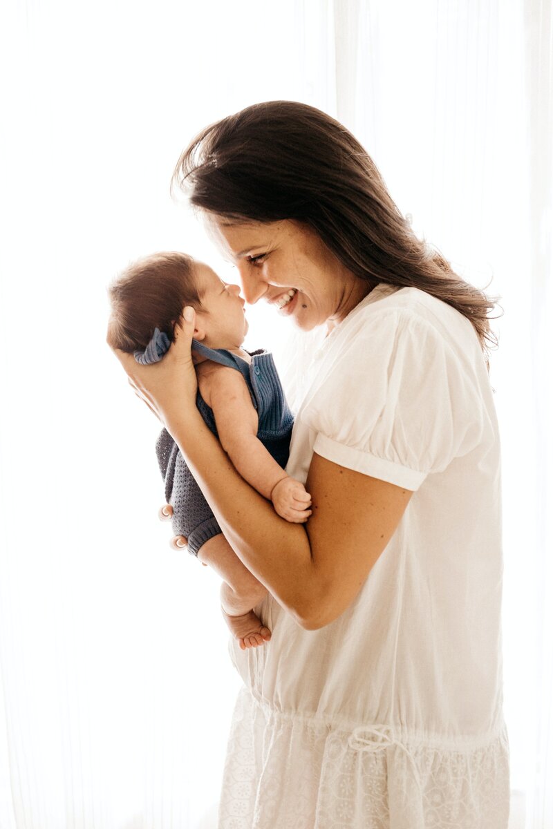 A mother gently carrying her newborn, symbolizing love, warmth, and the nurturing connection between parent and child.