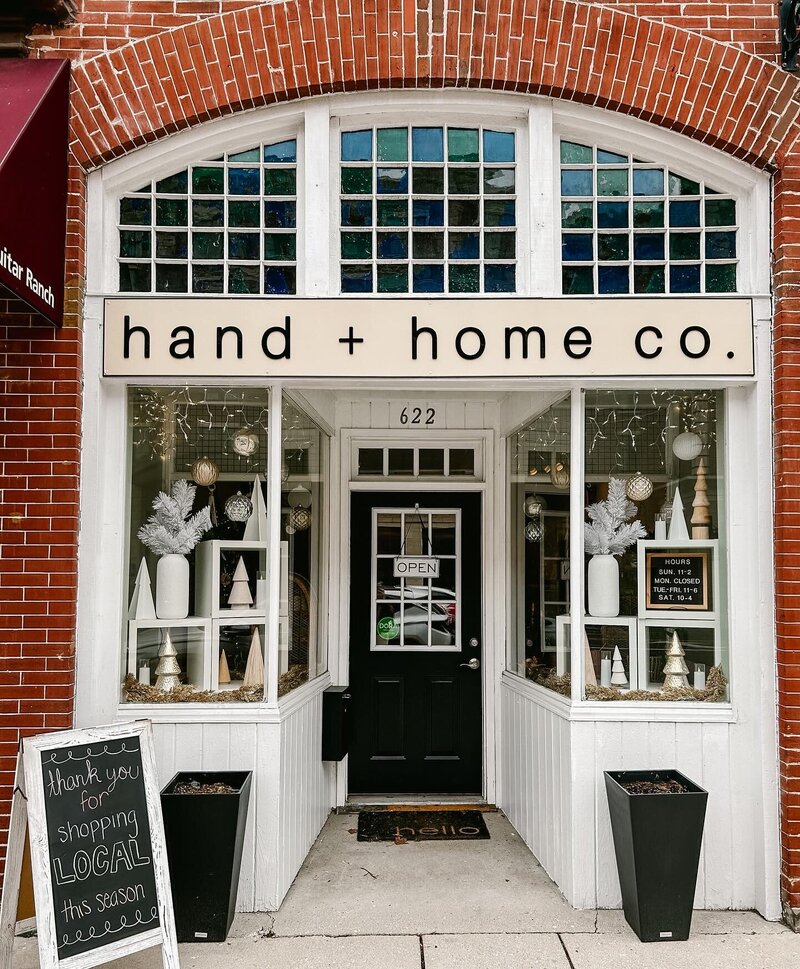 brick storefront with white windows with hanging disco balls