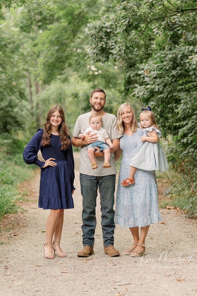 family of 5 posing together on a trail at mill creek preserve by york pa photographer