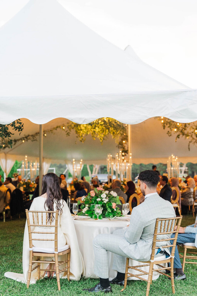 Bride and Groom sitting at their tented wedding reception