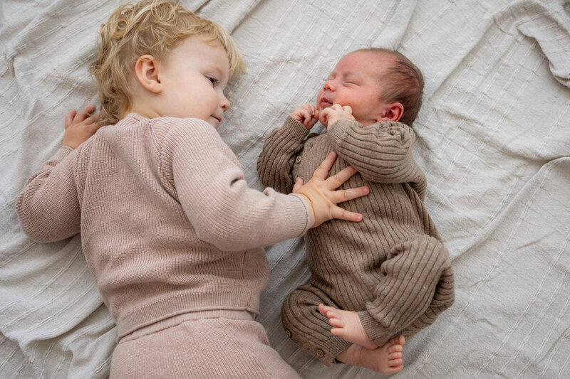 Newbornshoot thuis met grote broer op bed