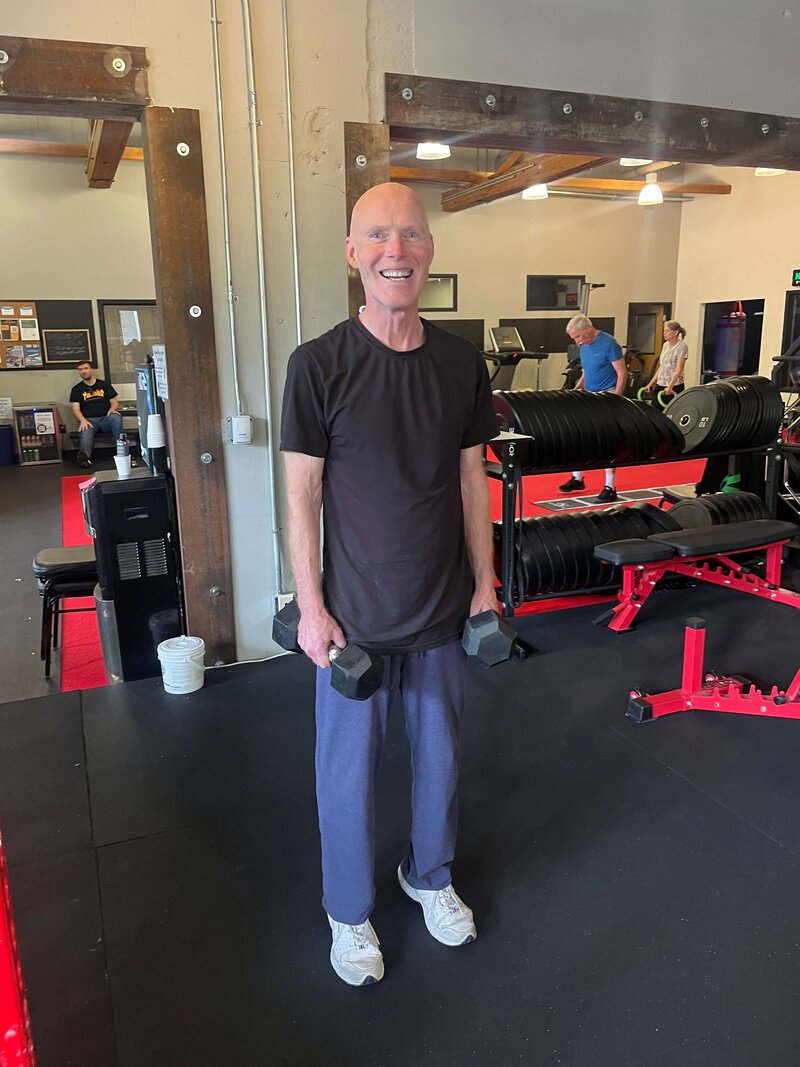A Parkinson's warrior holds weights in the Parkinson's Warriors Gym, representing one of many activities in the Parkinson's exercise classes.