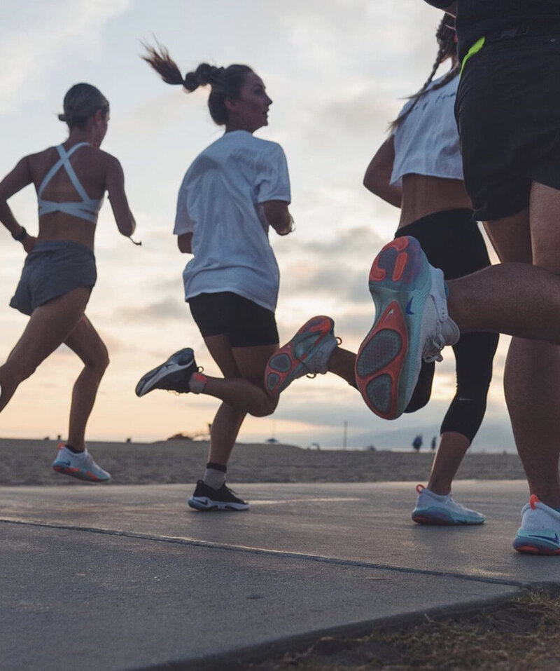 Group of women running together during HER Sports Club’s 5K training program.