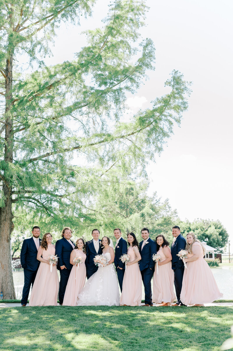 Wedding bridal party portrait with blush dresses standing next to the pond at Still Water Hollow in Boise