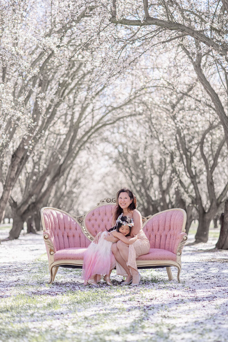 mom-daughter-loving-moment-pink-sofa-almond-orchard