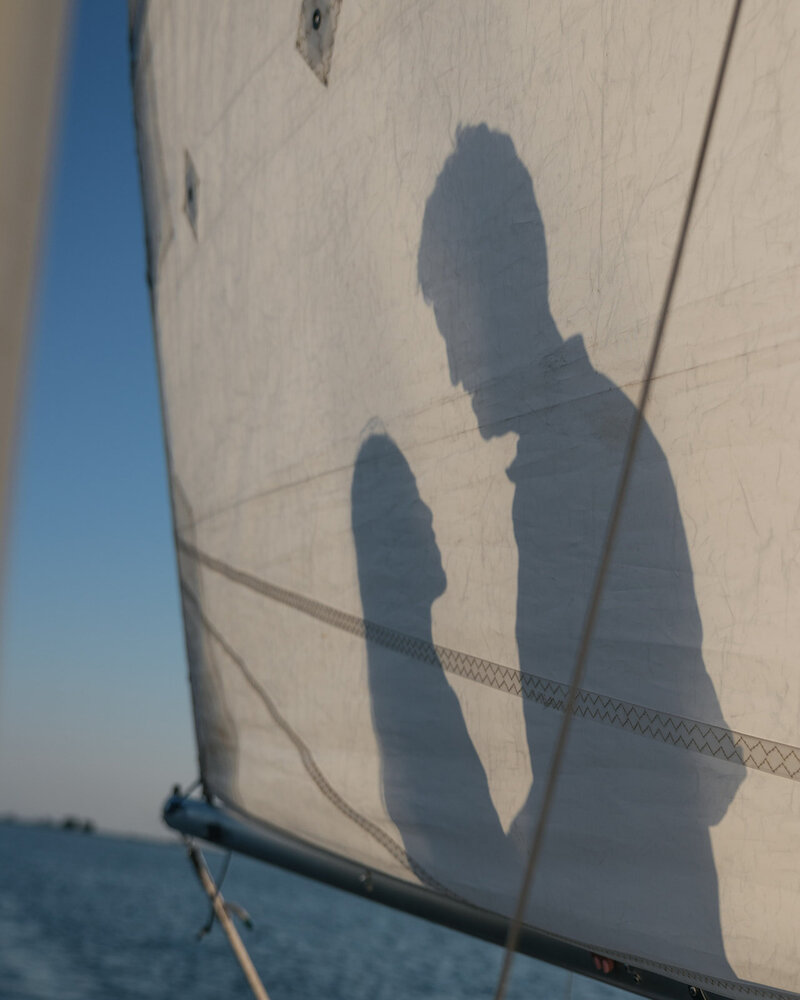 Couple relaxes on a sailboat under the sun