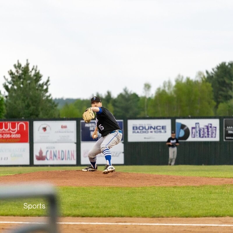 Baseball player mid-action during a game in Fredericton, showcasing sports event photography services.
