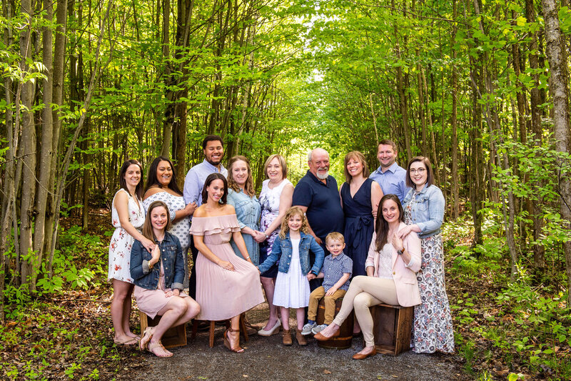 multigeneration family photo of grandparents, children and grandchildren in woods