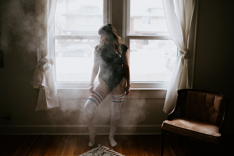 Woman at a window during a boudoir session in Indianapolis
