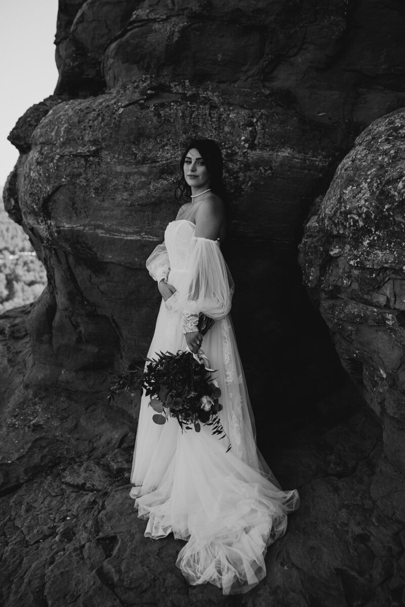 bride standing in the red rocks off the should boho dress