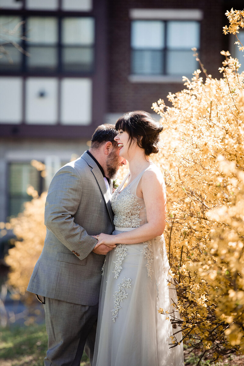 Couple sharing a sweet moment laughing and chatting together in their elopement attire near a beautiful yellow tree