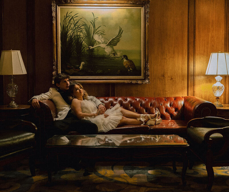 A wedding couple laying on a couch together.