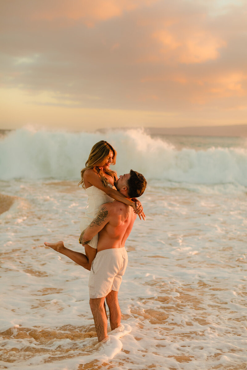 cute couple on the shoreline gazes into each others eyes and smiles with love and water photography