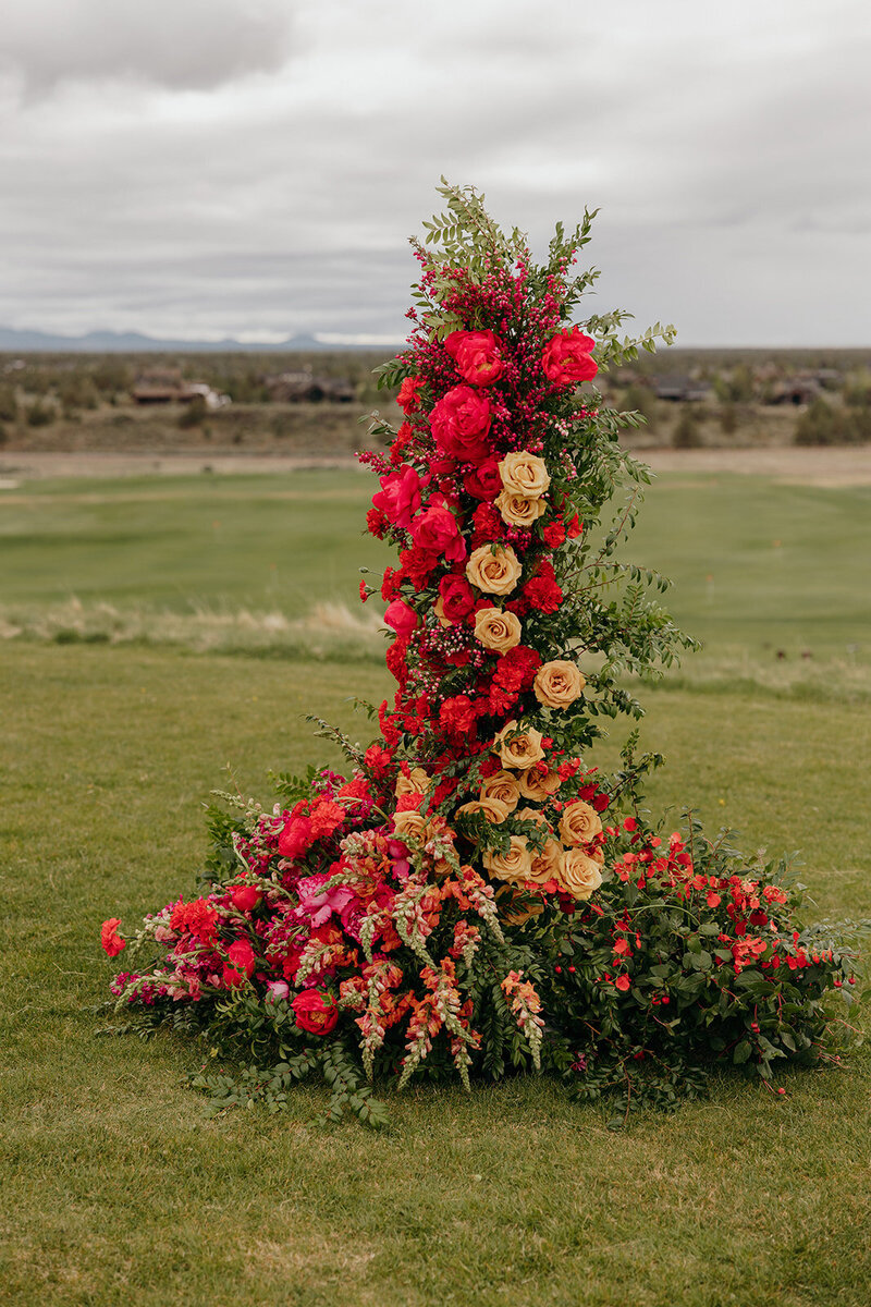 Colorful floral pillars at Brasada Ranch ceremony with mountain backdrop