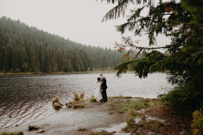 a mand and woman in wedding attire stand on the rocky beach shores of Yachats in Oregon