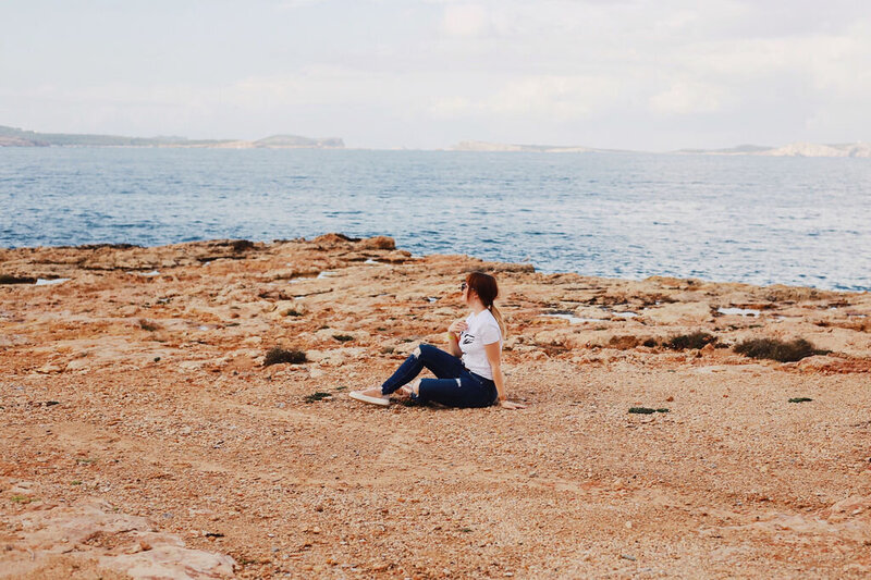Personal Branding Foto einer Frau auf Felsboden mit Blick aufs Meer

