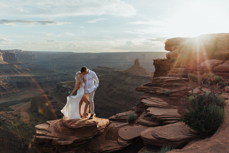 bride and groom walking on red rocks