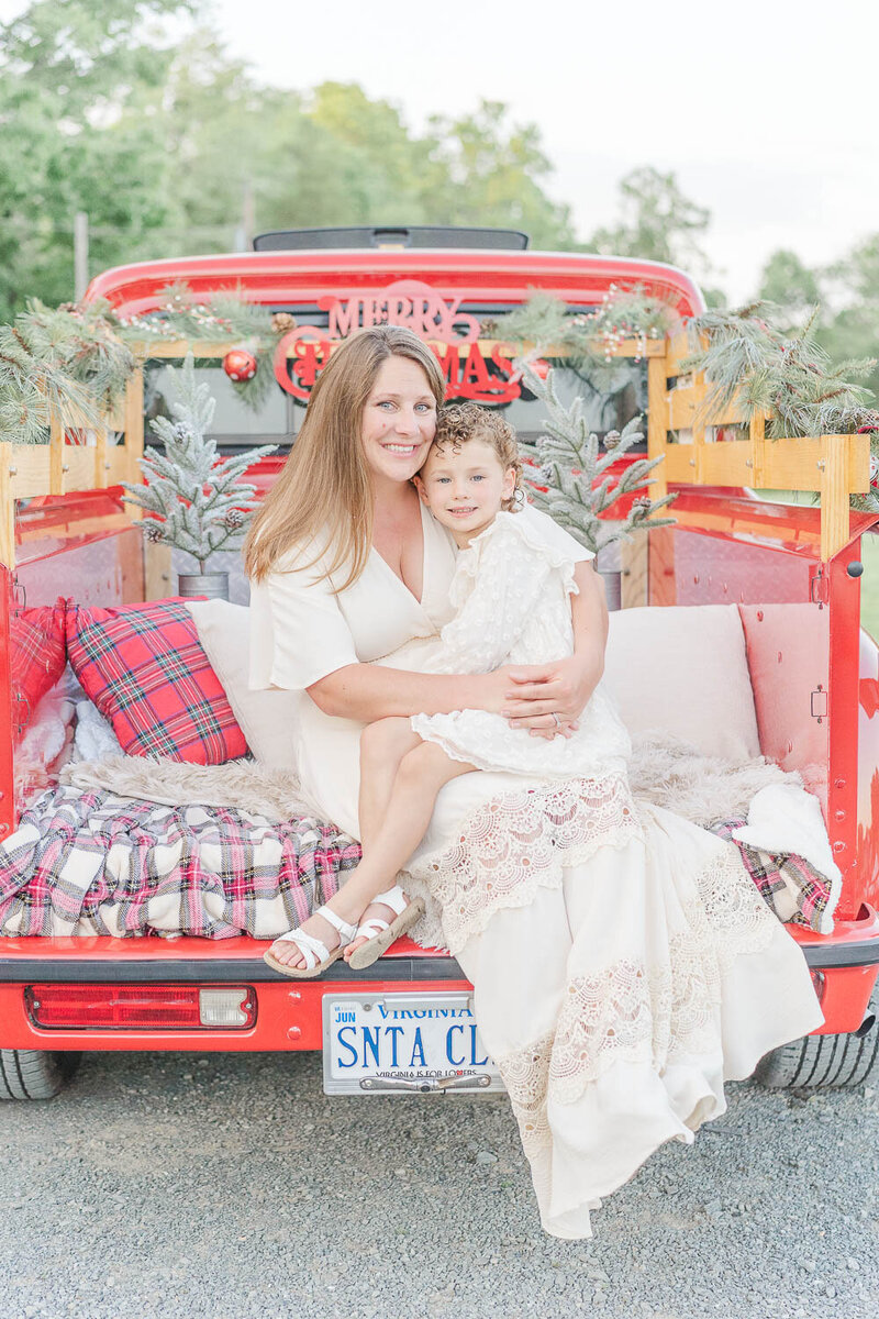 mom hugging daughter during red truck mini session in Northern Virginia