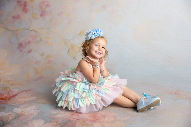 Child wearing floral crown in pastel couture gown studio portrait near Stockdale