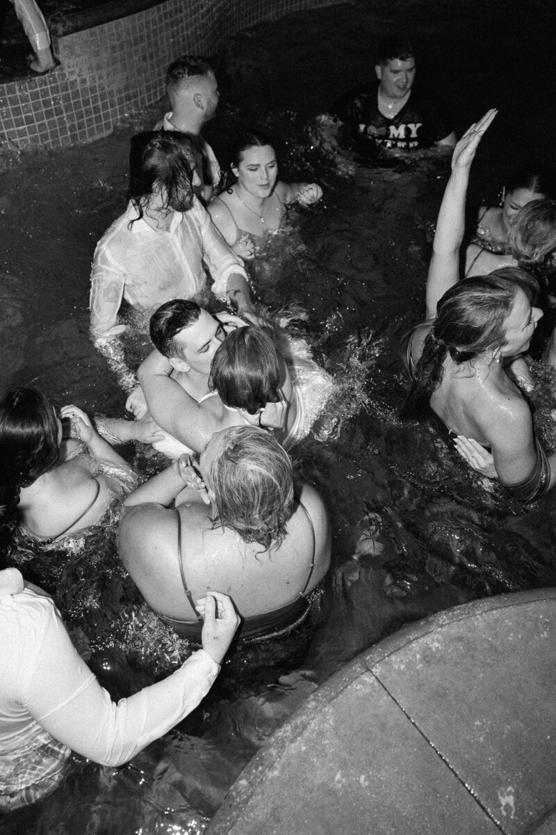Bridal party jumps in the pool during the reception