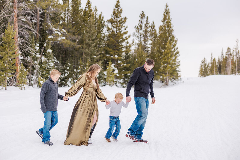 Family walking together during their snowy family session in the Snowy Range Mountains.