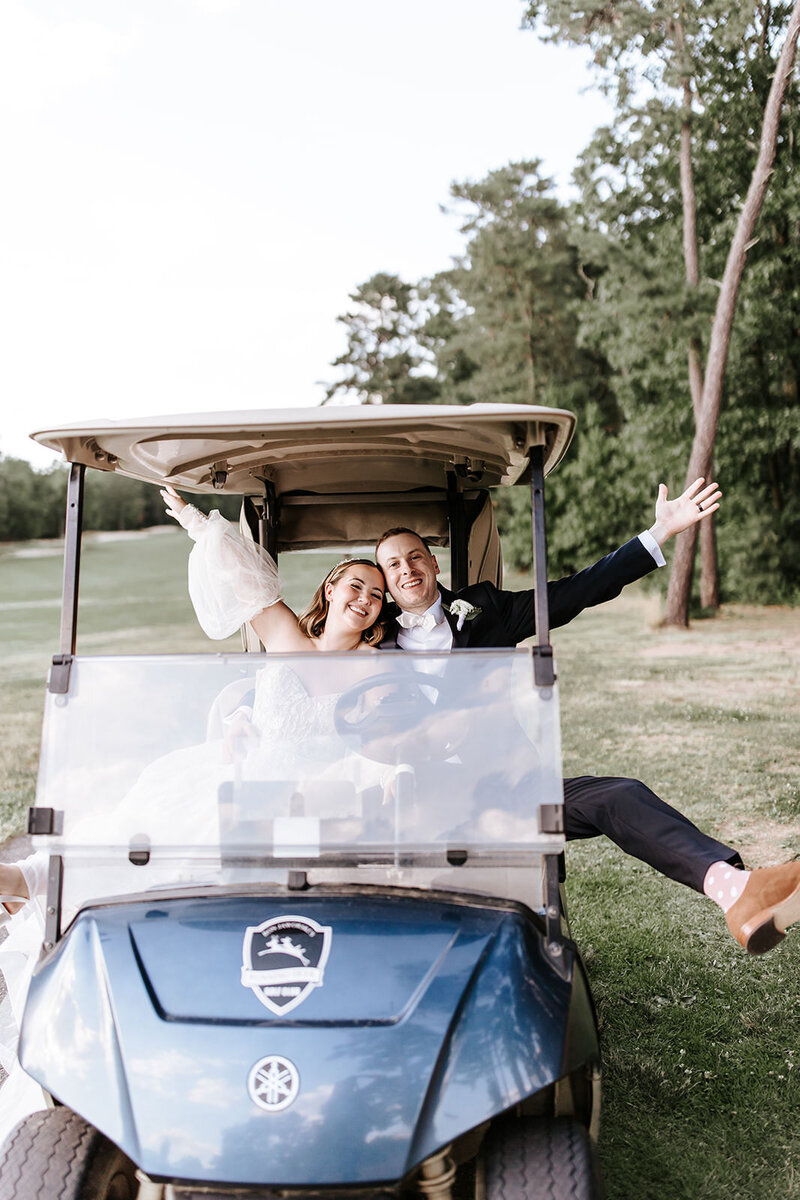 Groom hysterically cries as he sees bride walking down the aisle, in front of fall foliage trees.