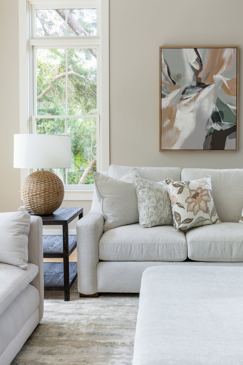 Cozy living room with a neutral sectional sofa, abstract artwork, and soft textures for a relaxed, elegant design.