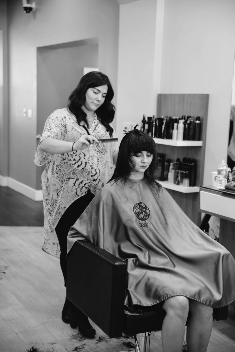 Liz Colasurdo, owner of Artisan Salon , cutting hair for a client