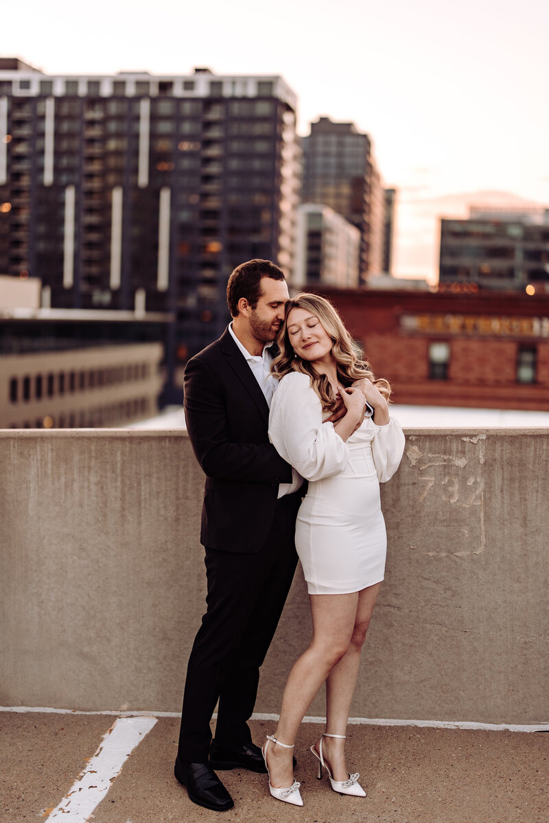 engaged-couple-on-city-rooftop-smiling