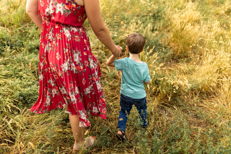 Image of Jenaveve, matrescence coach, and her child walking in a field