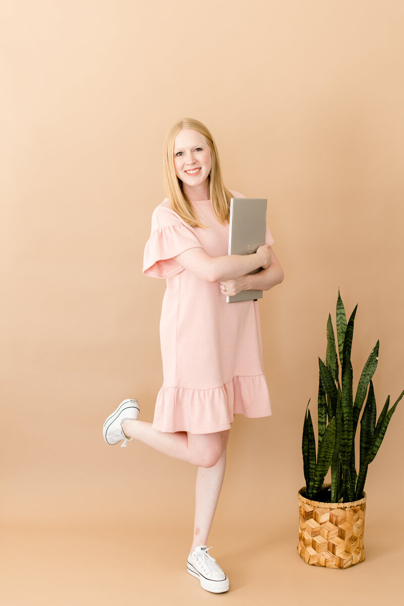 Young virtual assistant holding laptop smiling