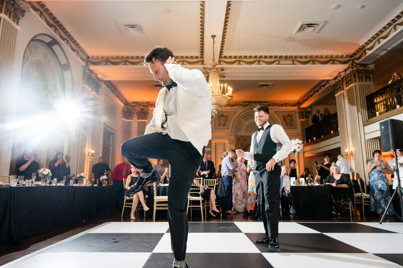 black and white checkered dance floor in george washington hotel with groom dancing fun