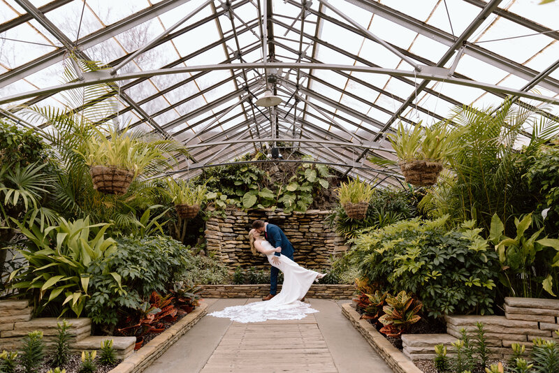 Groom dipping bride for a kiss at Rockefeller Park Greenhouse in Cleveland.