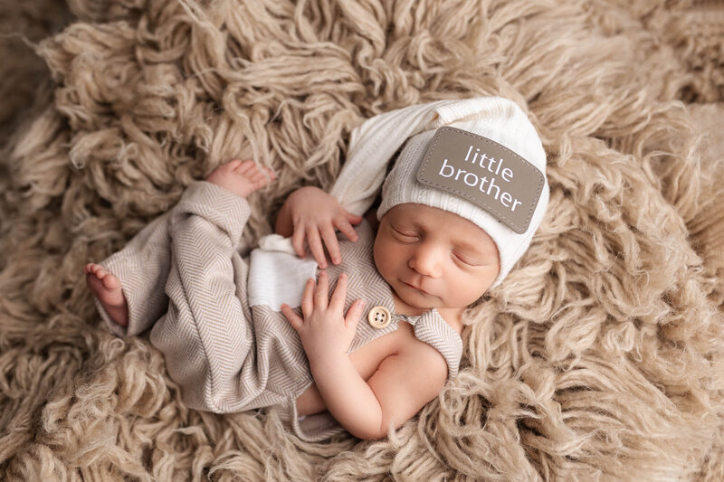 Newborn baby boy wrapped in an apricot colored wrap.