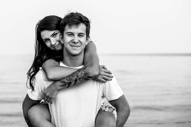girl piggybacks boyfriend at the beach