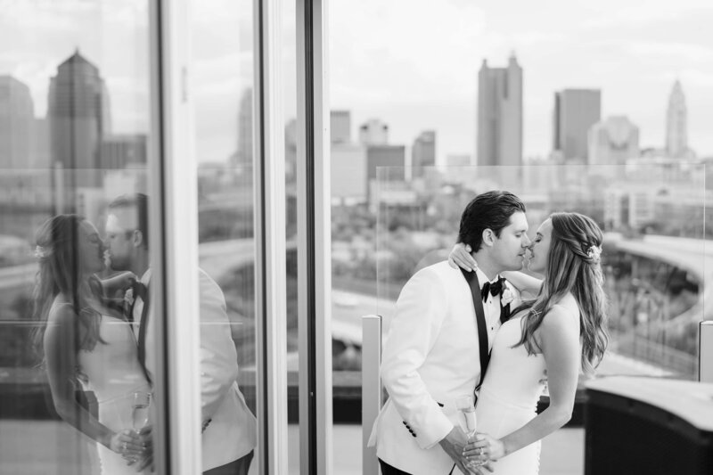 A newly married couple shares a kiss on the patio of Revery overlooking downtown Columbus