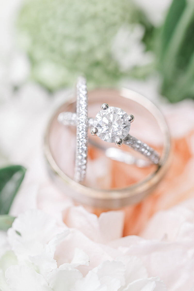 A pair of delicate blue bridal shoes beautifully arranged among soft pastel florals, creating a romantic and timeless detail shot for the wedding day.