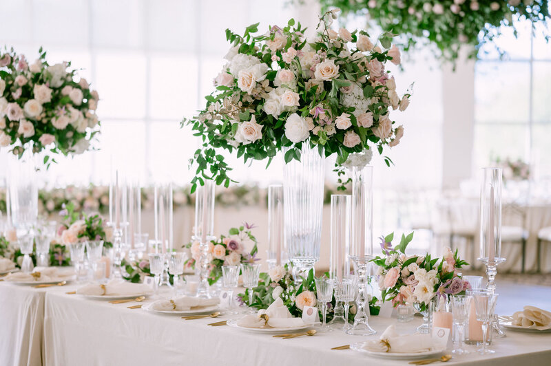 Elegant wedding reception tables with tall lush floral arrangements