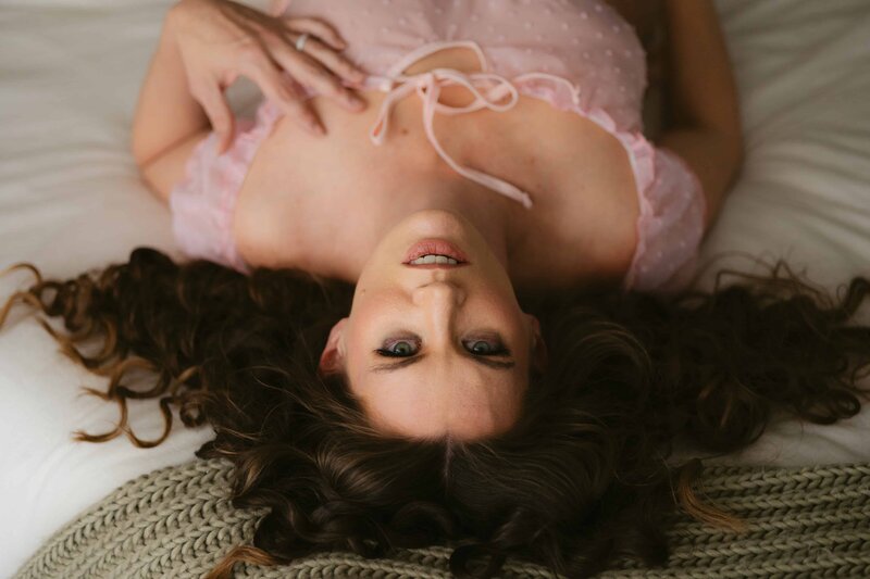 Colorado Springs boudoir model lying on bed with angle from above