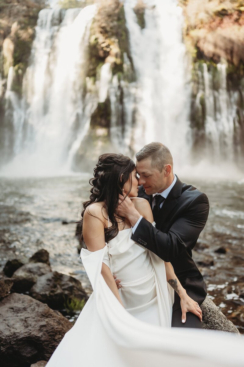 Bride and groom portrait in front of a waterfall